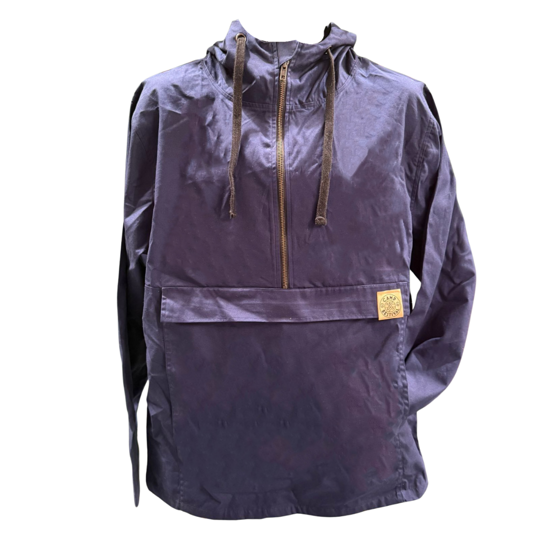 The Camp Bestival Smock Jacket Atlantic by Camp Bestival is a navy blue hooded pullover with a front zipper, large pocket, brown drawstrings, and a small tan patch with text sewn onto the pocket.