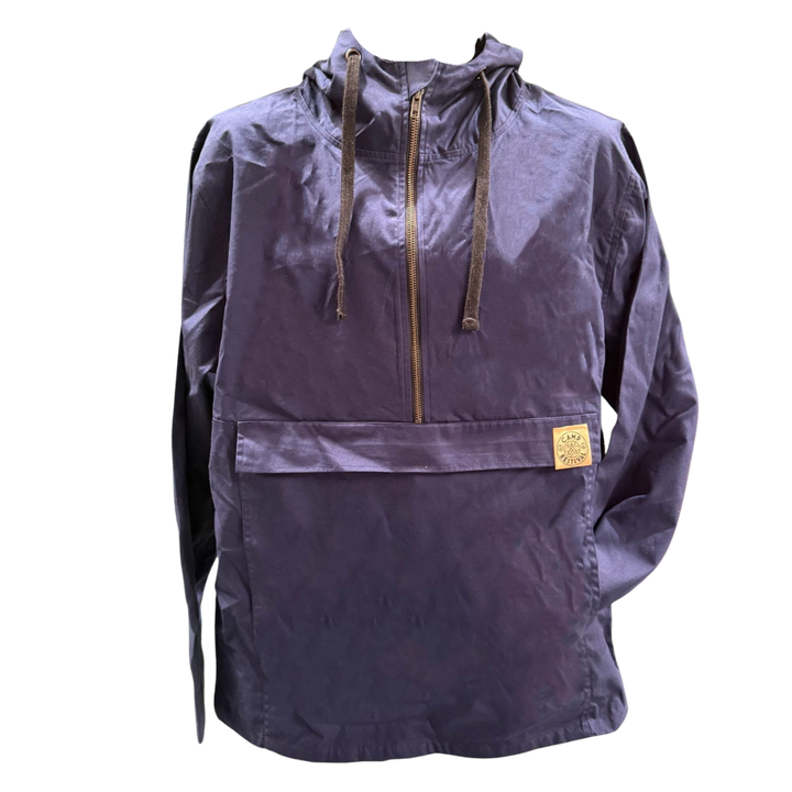 The Camp Bestival Smock Jacket Atlantic by Camp Bestival is a navy blue hooded pullover with a front zipper, large pocket, brown drawstrings, and a small tan patch with text sewn onto the pocket.