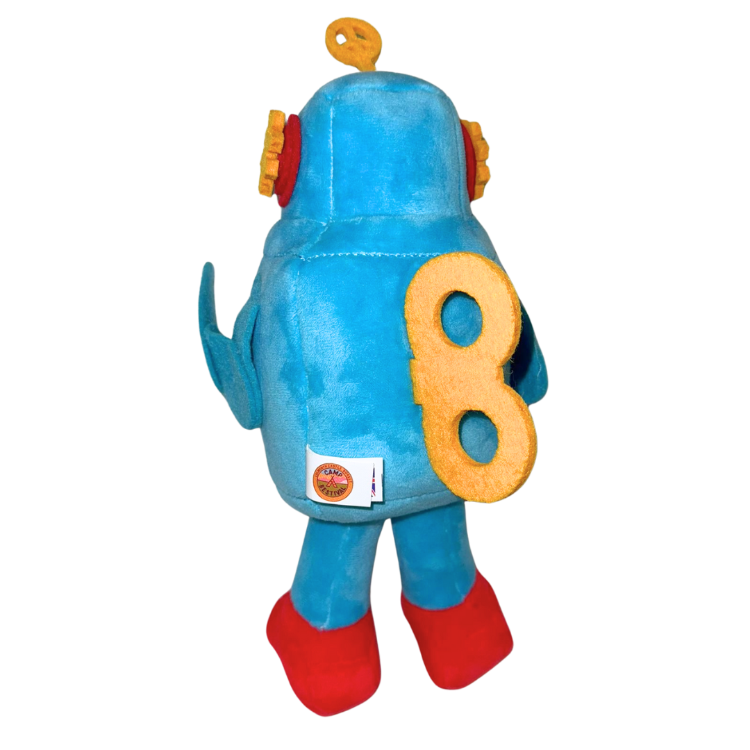 The Camp Bestival Love-Bot Plush by 2025 is a blue plush toy robot with red feet, orange ear-like details, and a large yellow number 8 on its back, standing upright and facing away.