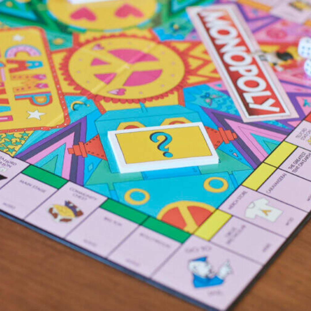 A close-up of the Camp Bestival Monopoly board game by Camp Bestival shows the colorful center with a yellow question mark card, visible Monopoly logo, property spaces, and dice on this limited-edition set.